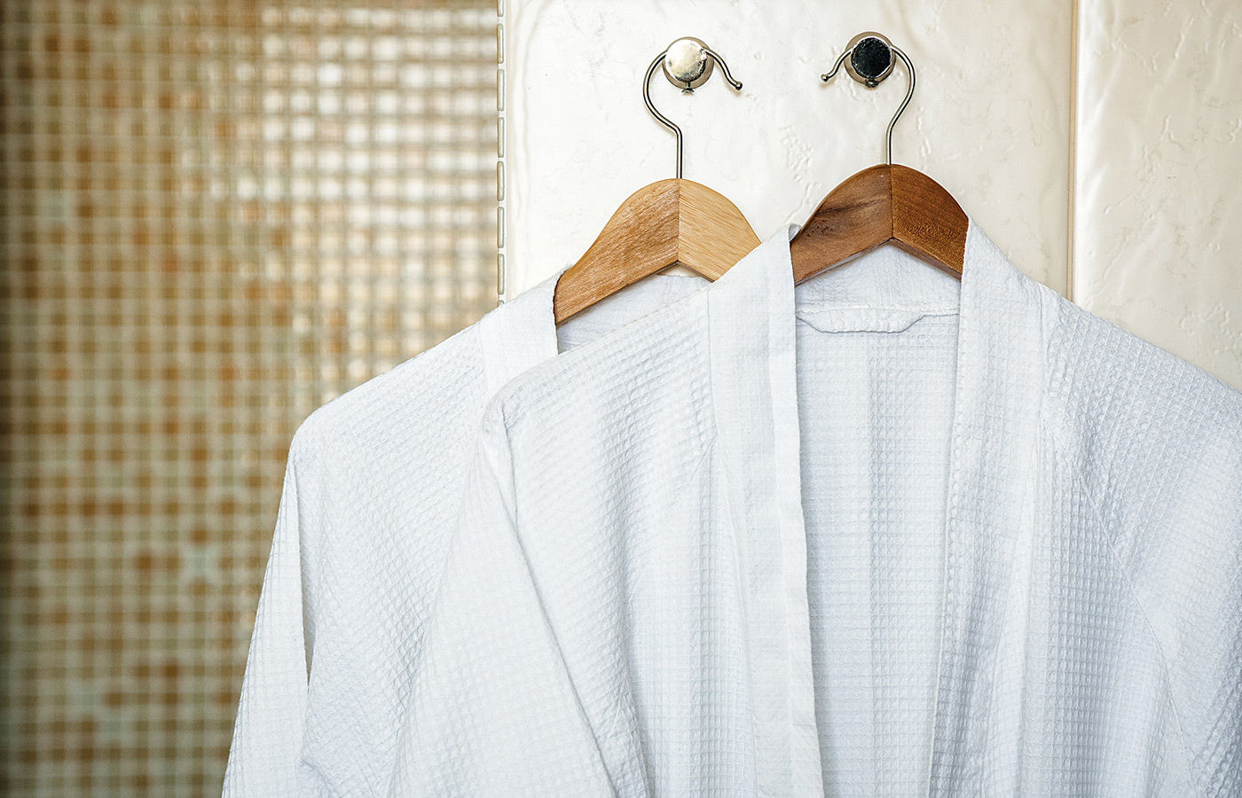 two white robes hanging in spa