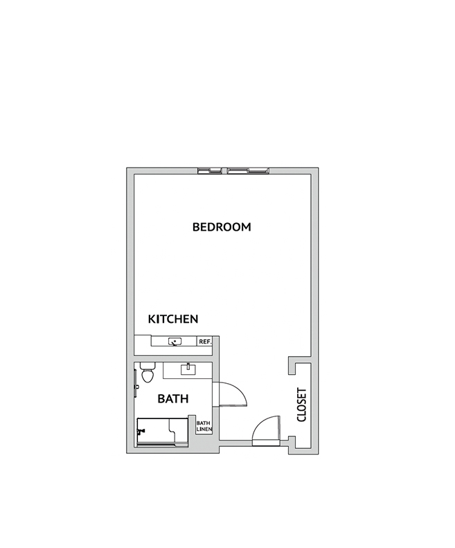 An assisted living studio suite floor plan with an open living/bedroom space and kitchenette.