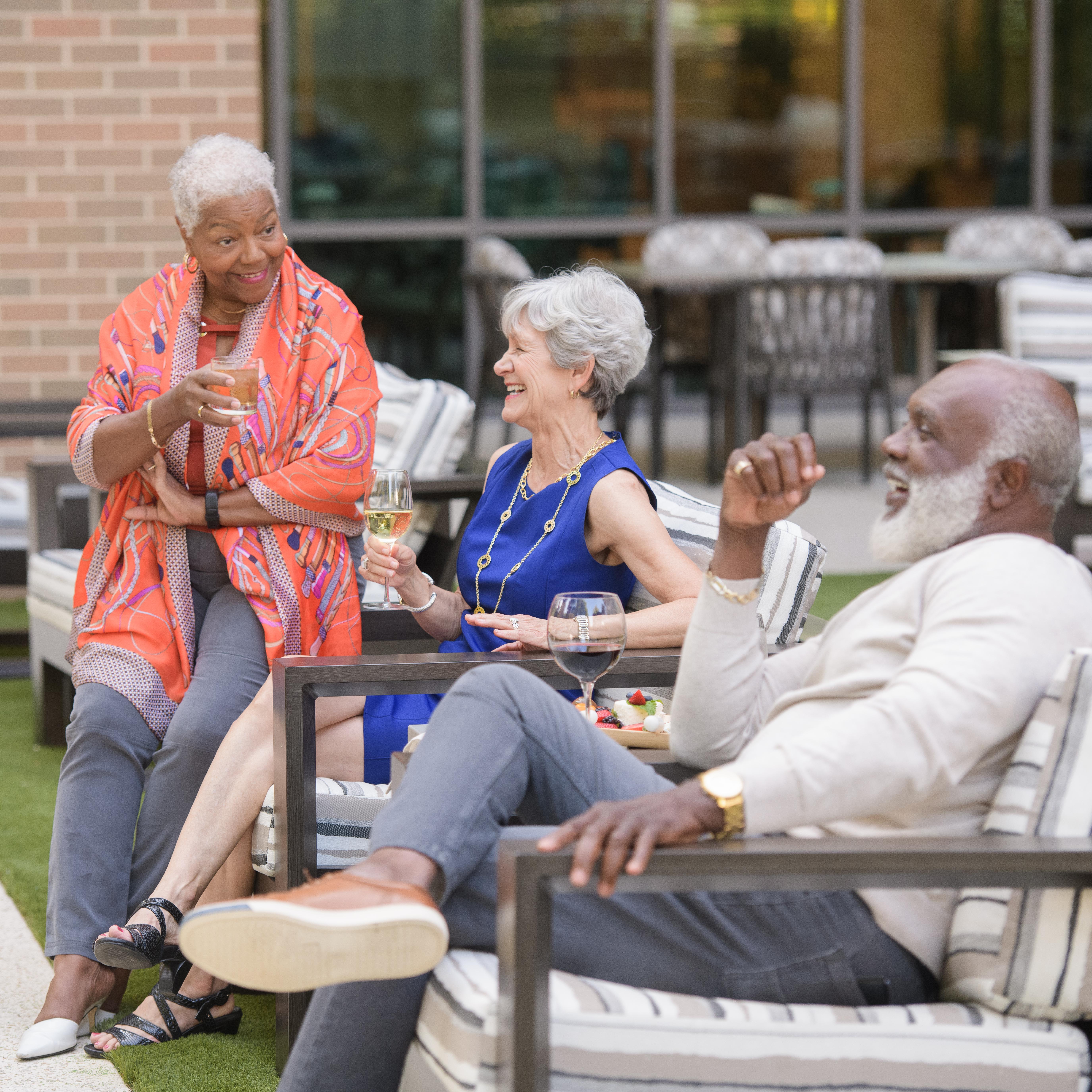 thee people sitting on chairs outside