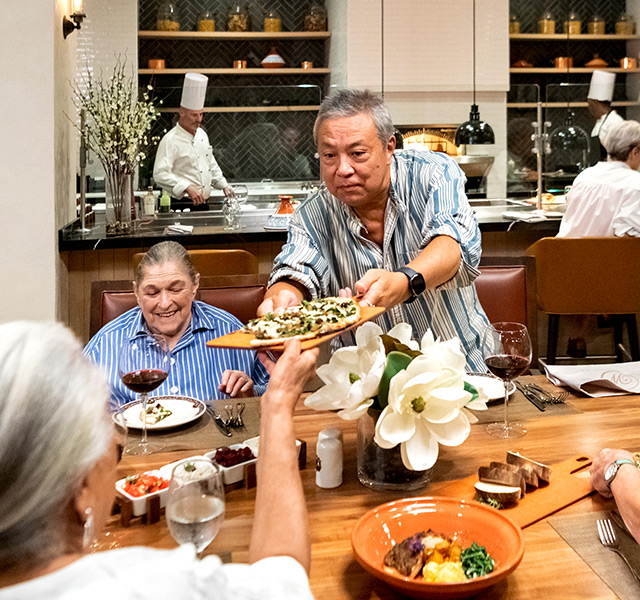 Residents gathered around a table full of good food.