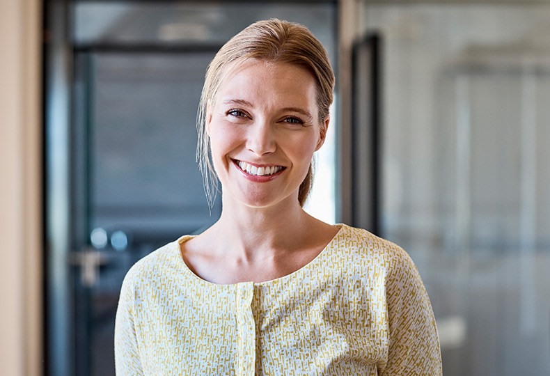 Blonde associate looking at camera smiling.