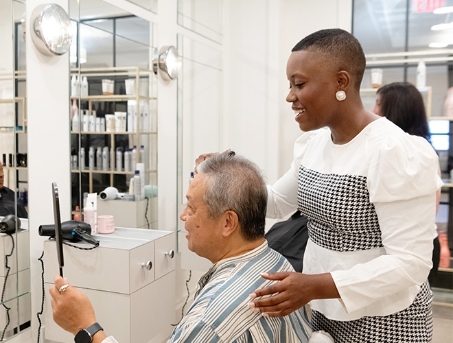 Person cuts resdient's hair in salon.