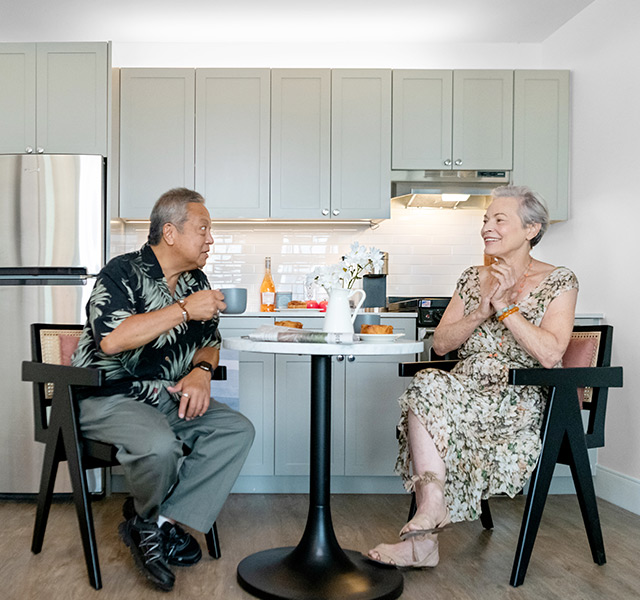 Residents sitting at table laughing.