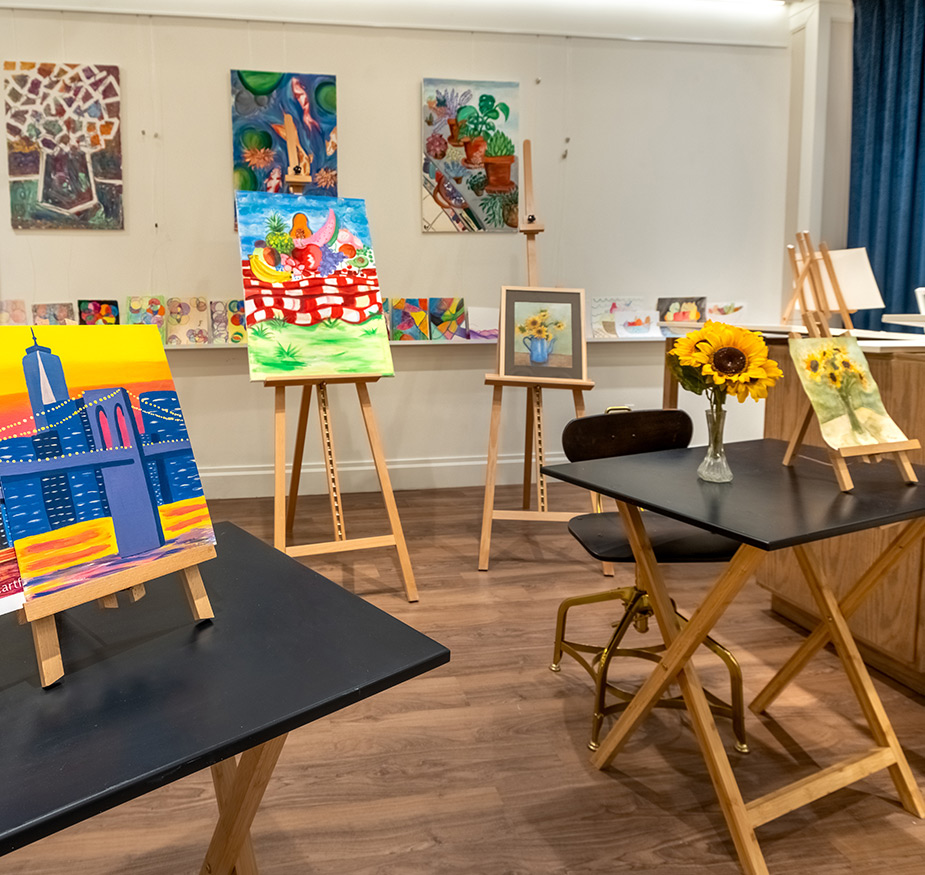 The art room filled with colorful paintings on easels.