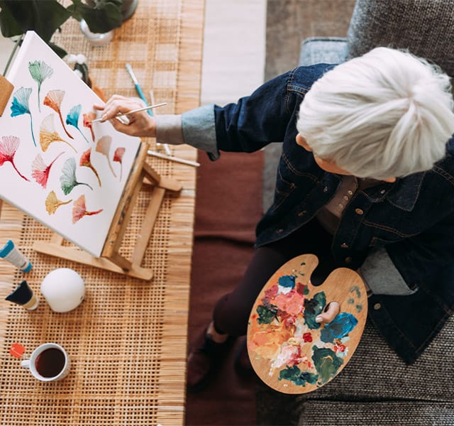 A resident doing a water color painting activity.