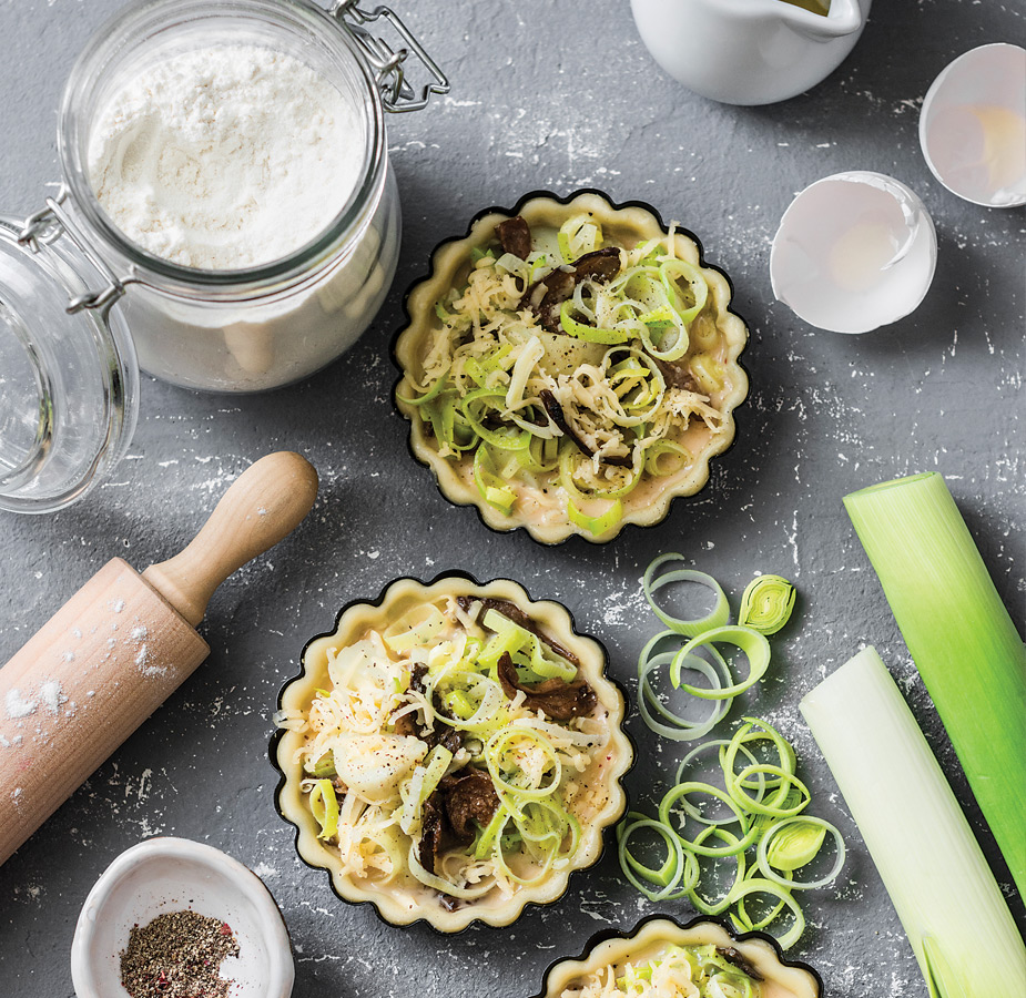 Two small pastries with rolling pin and canister of sugar.