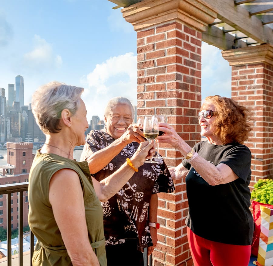 Residents toasting with drinks on the rooftop.
