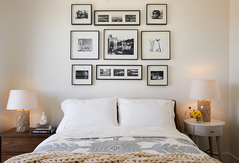 Bed with pillows and blankets and pictures on the wall.