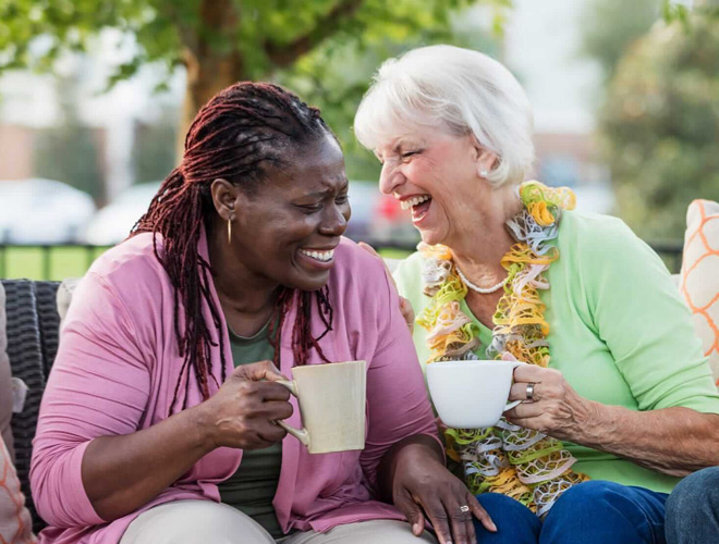 Two residents laughing and enjoying coffee together.