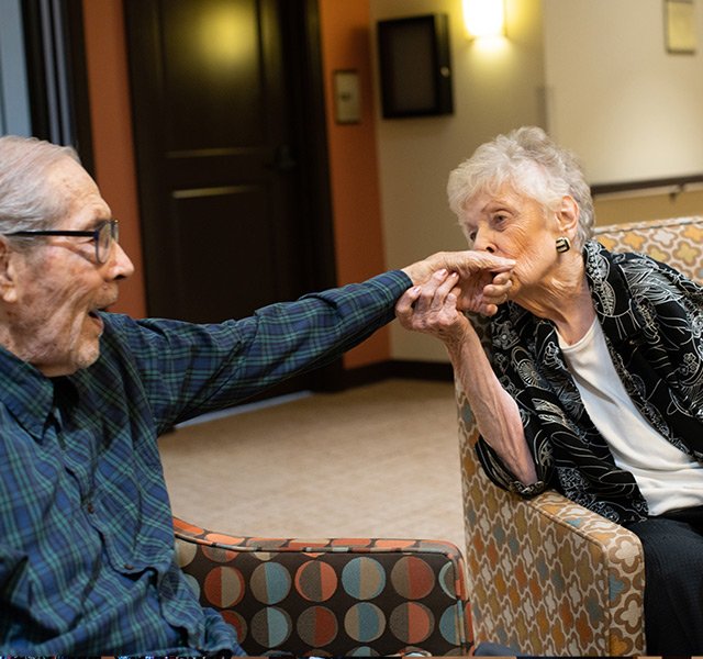 One resident kissing another residents hand.