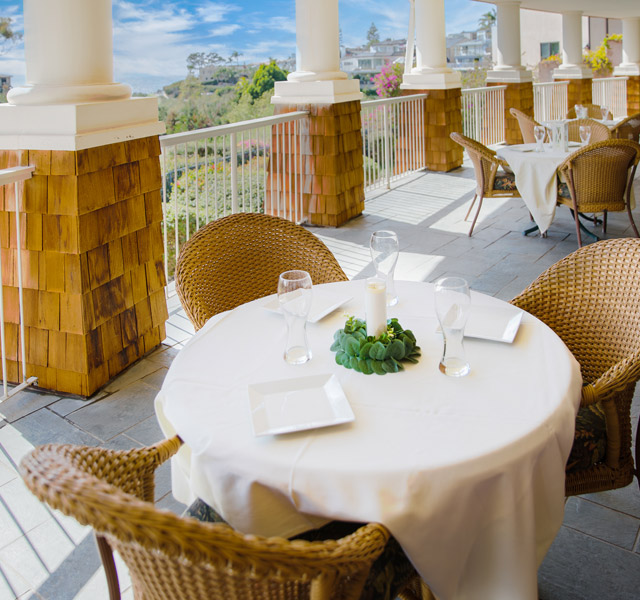Outdoor dining at Crown Cove on a patio with an ocean view.