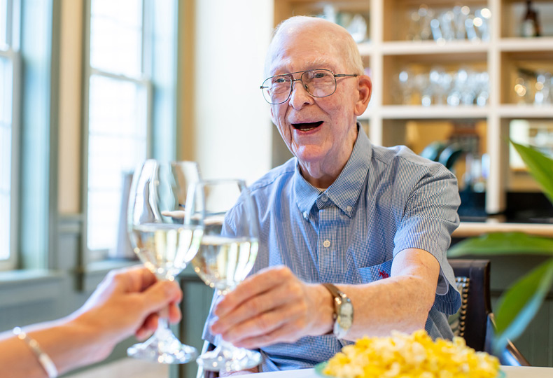 A resident is clinking their glass with another resident.