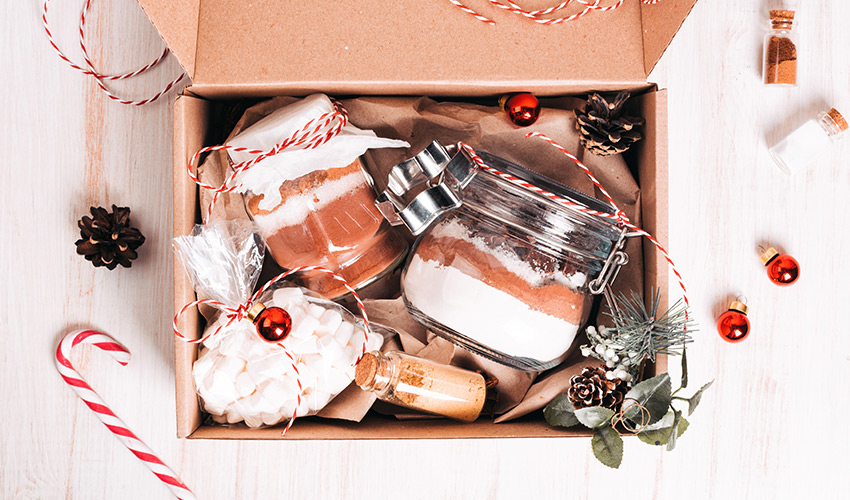 A box filled with mason jars with ingredients inside to cook. 