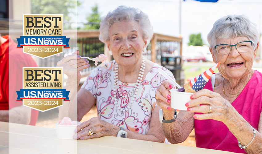 Two people at a picnic table with ice cream.