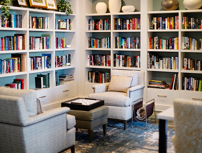 A library with chairs and shelves of books.