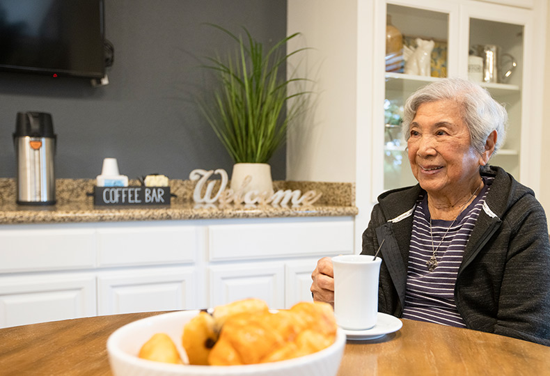 A resident is sitting at a table at Fremont Hills.