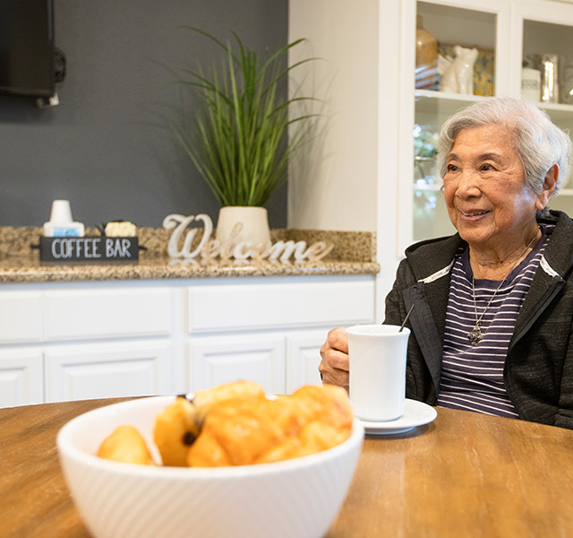 A resident is sitting at a table at Fremont Hills.