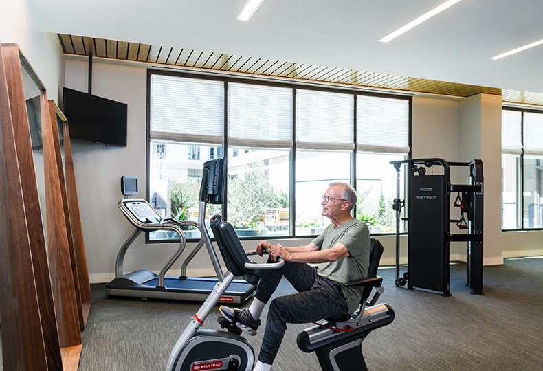 A resident on a fitness machine in the fitness area.