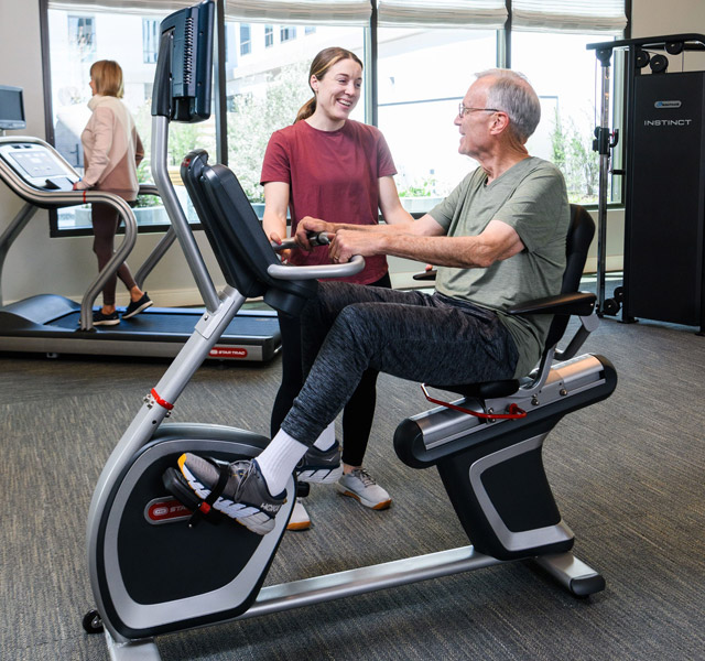 A resident on a fitness machine in the fitness area.