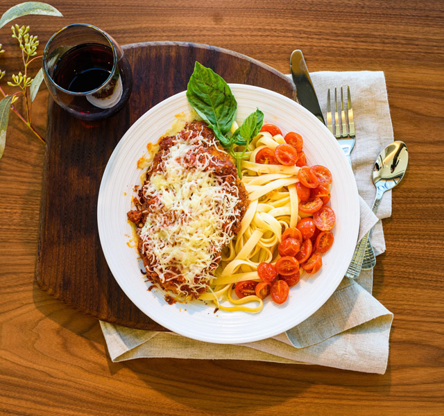 A plate of spaghetti and a glass of wine.