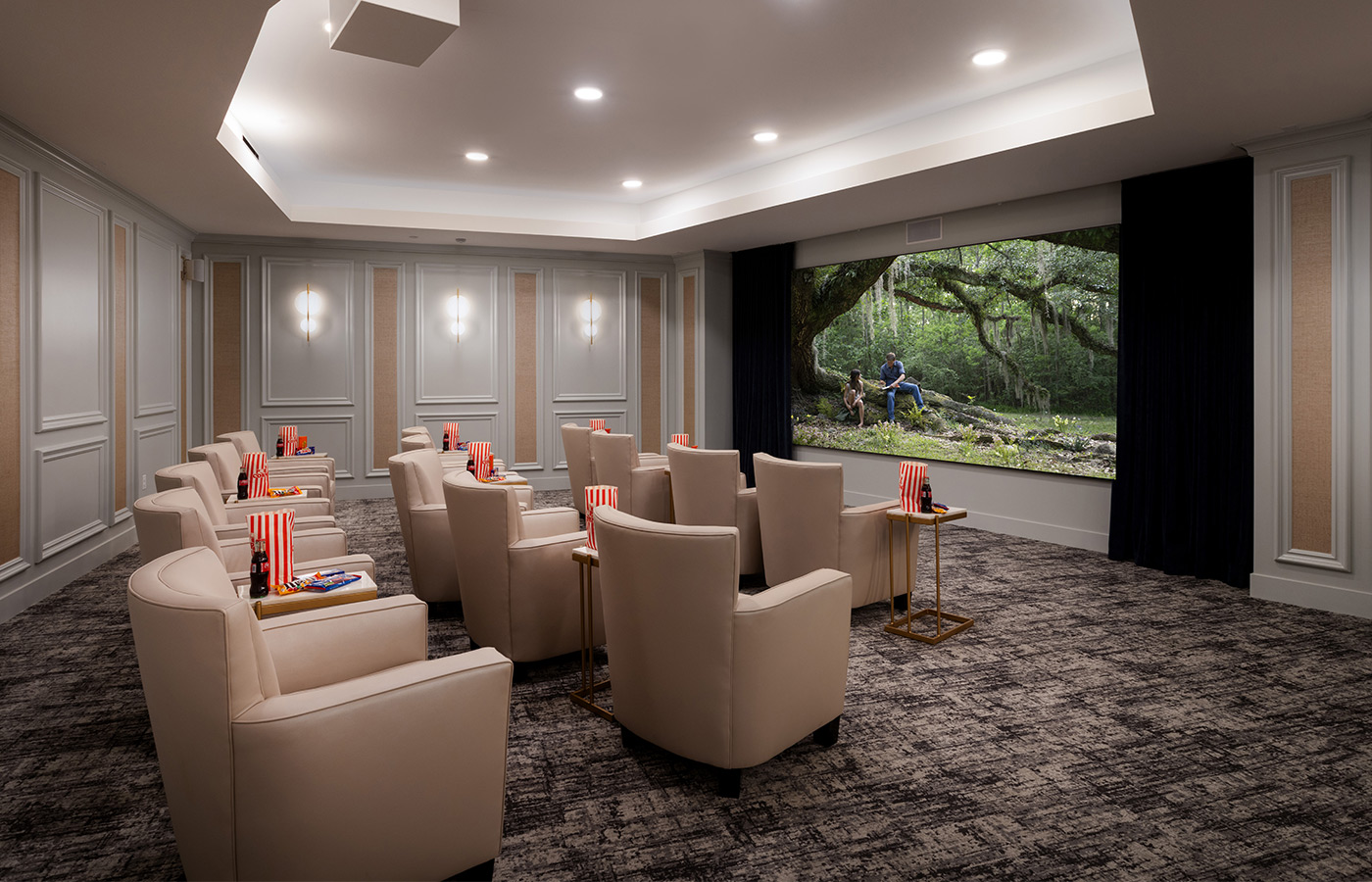 A theater room with comfy seating and a large screen.