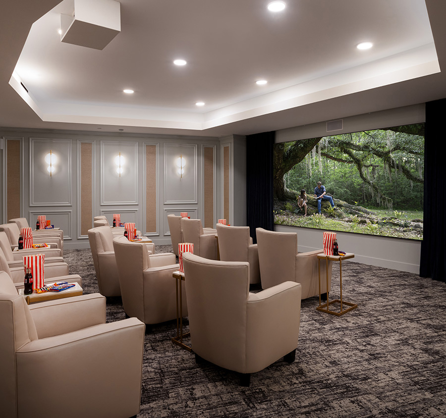 A theater with large comfy chairs and a big screen.