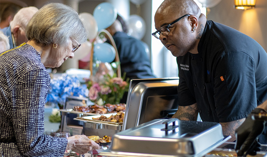 A resident getting food from the buffet.