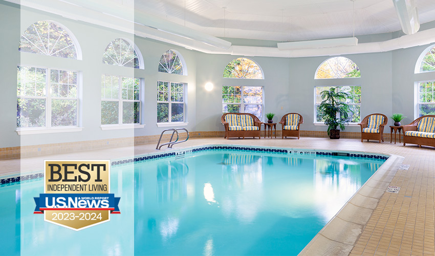 An indoor pool with lots of windows.