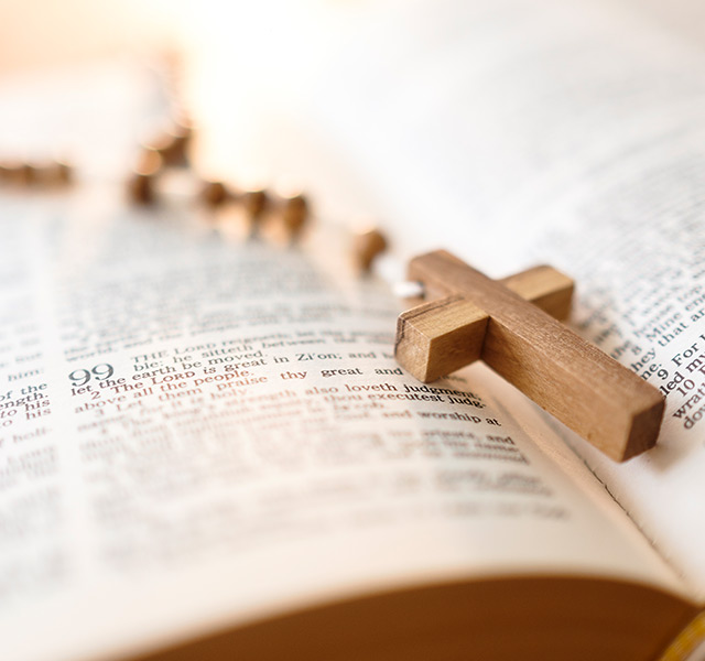 A small wooden cross on a bible.