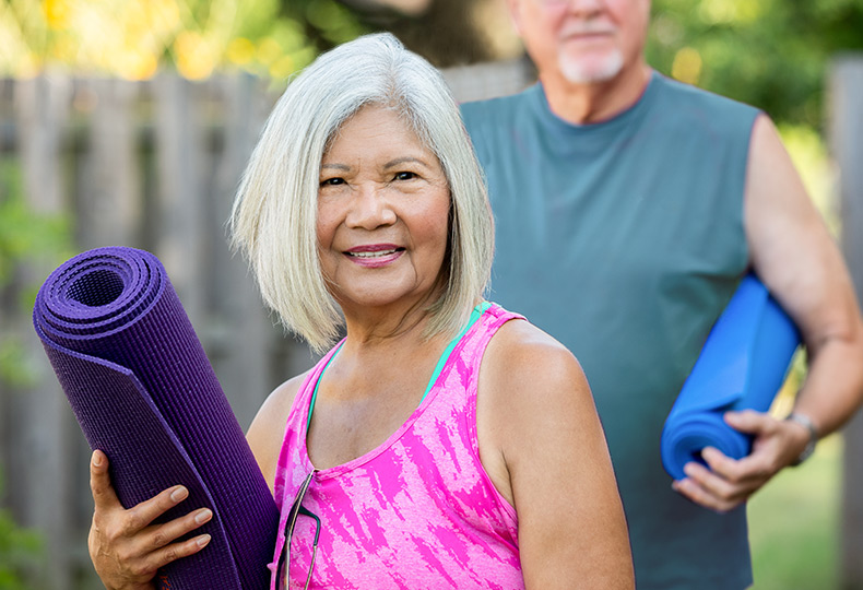 A resident is holding a yoga mat.
