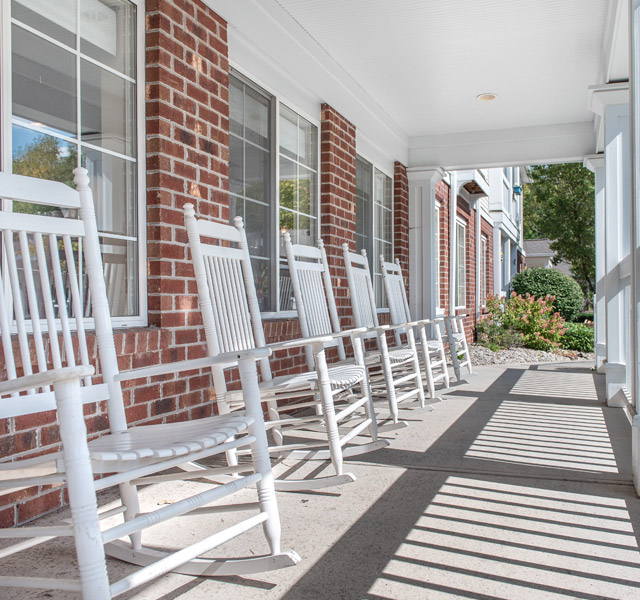 A front porch with rocking chairs.