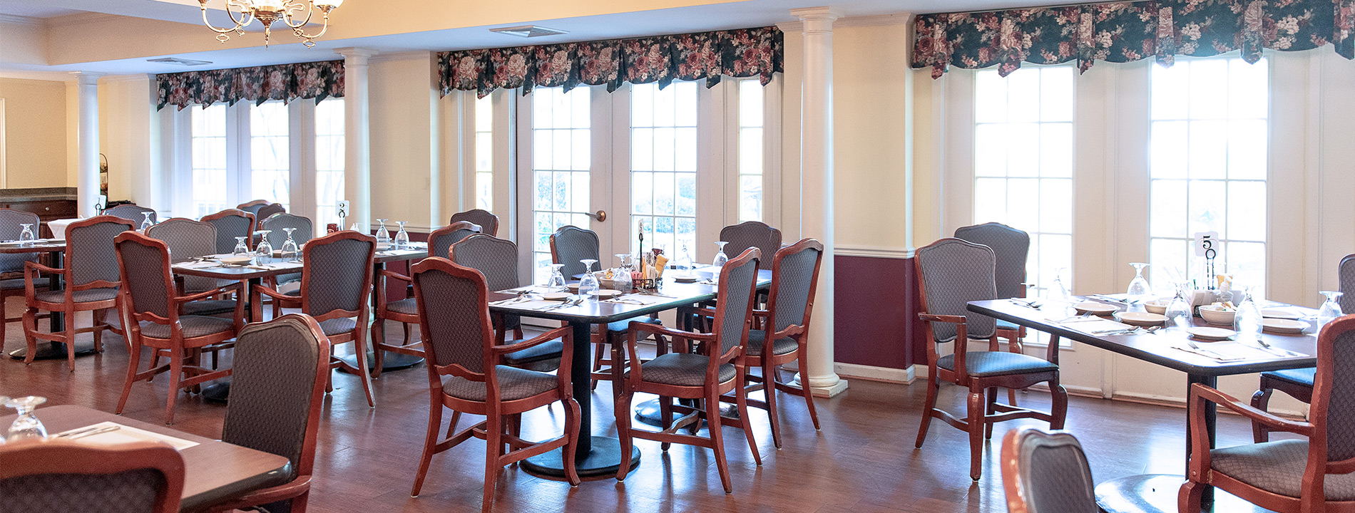 casual dining area with set tables, chairs and bright windows
