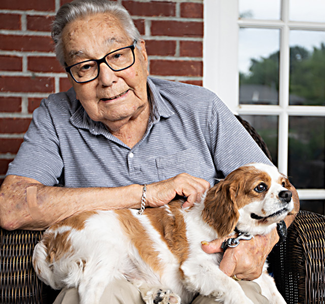 A resident is holding a dog.