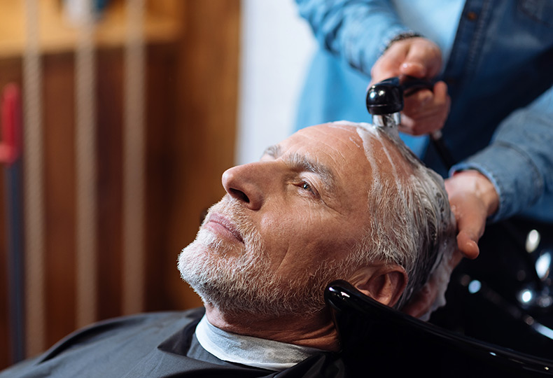 A resident is at the salon getting their hair washed.