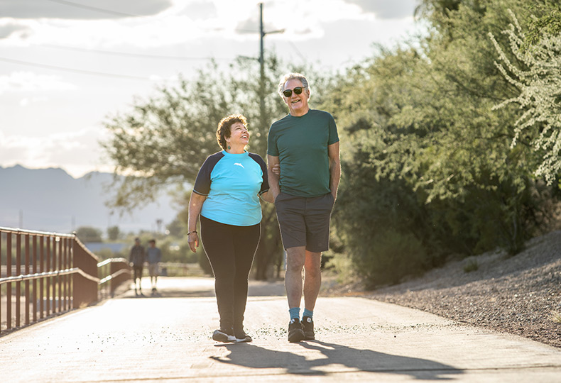 Two residents are walking on an outdoor pathway.