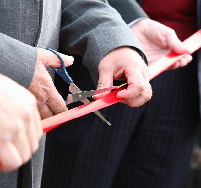 A person is cutting a ribbon.