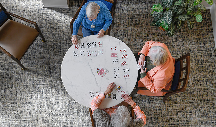 overhead view of three friends playing a game of cards