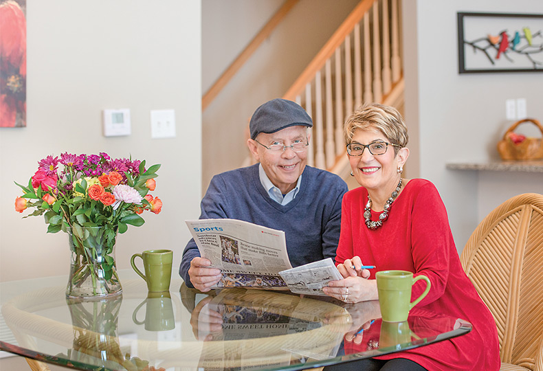 People sitting at the counter with a newspaper.