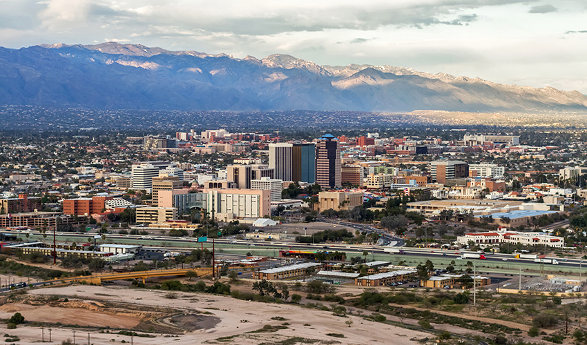 An serial view of the city of Tucson with mountains in the back.