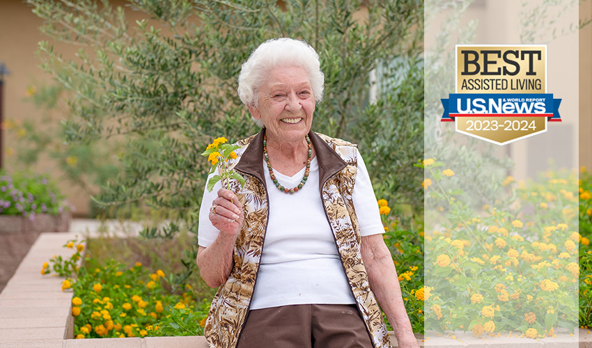 A person holding a flower in the garden.
