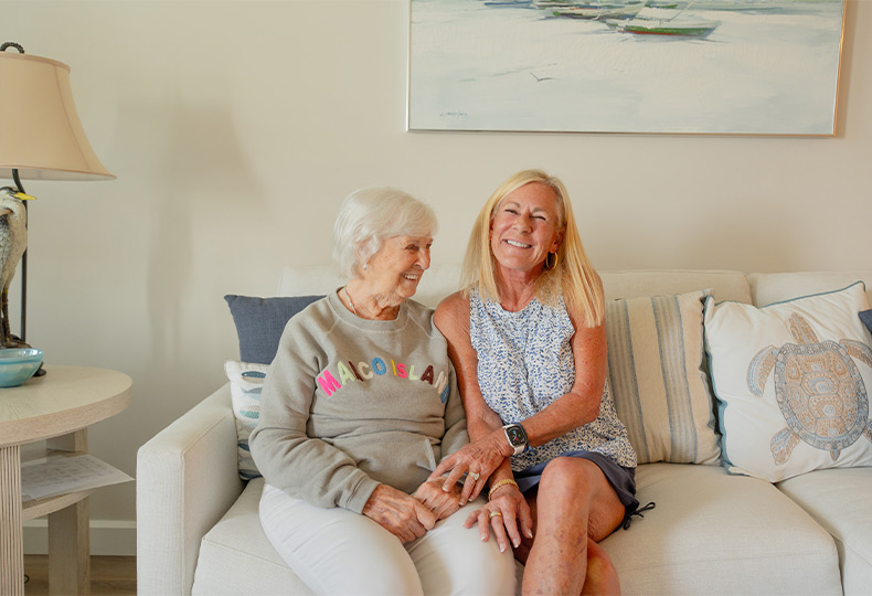 Two people laughing on a couch.