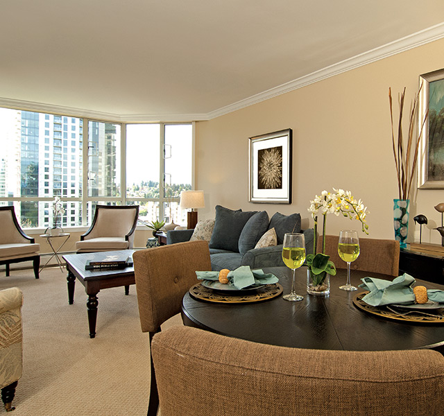 A fully furnished open dining room looking into the living room.