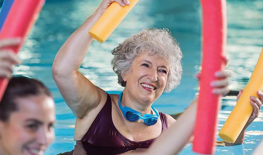 Senior ladies in the pool with foam noodles.