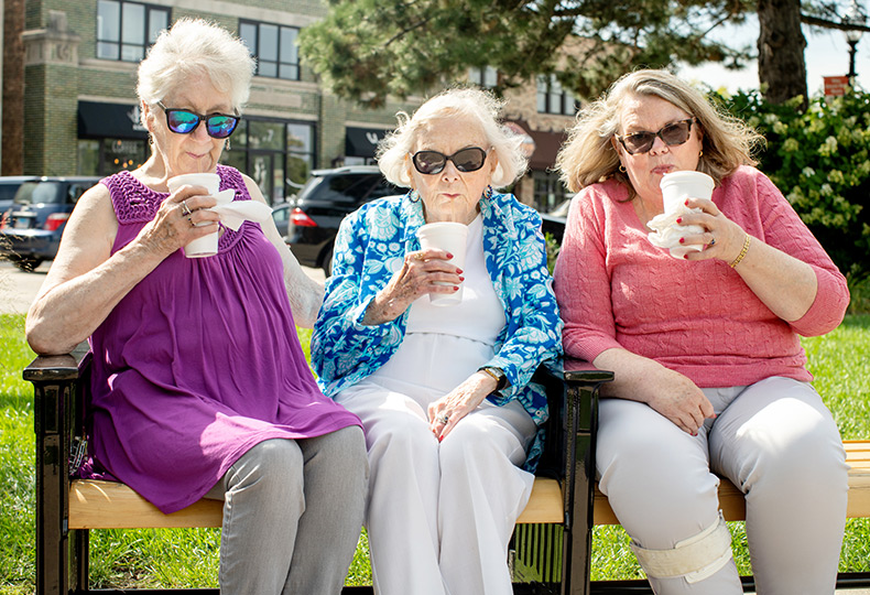 Three residents wearing sunglasses sitting down to have a drink.
