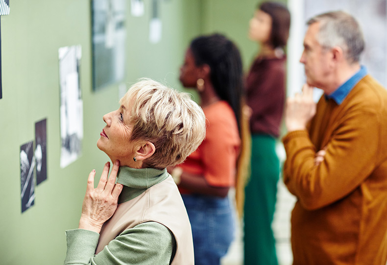People at museum looking at art on the wall.