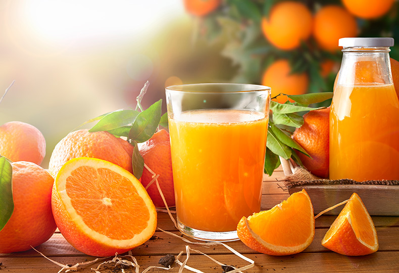 Oranges and glass of orange juice.