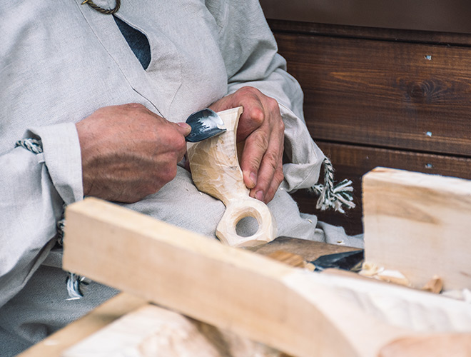 A resident carves wood sculpture.
