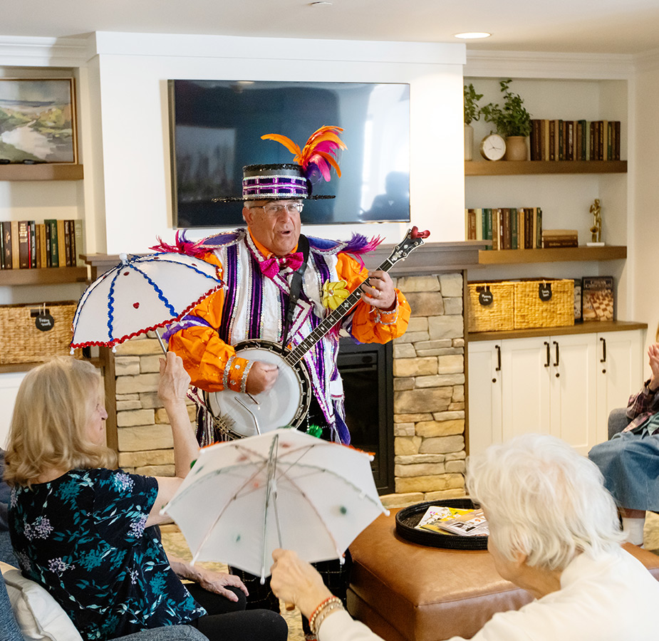 A person playing the banjo that is dressed very colorfully.