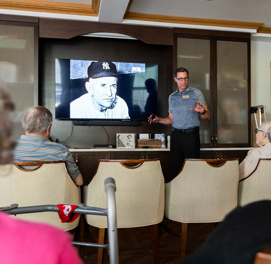 A group of people watching a presentation on baseball.