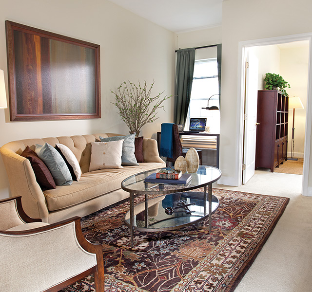 Furnished living room space with sofa, table, and seating area.